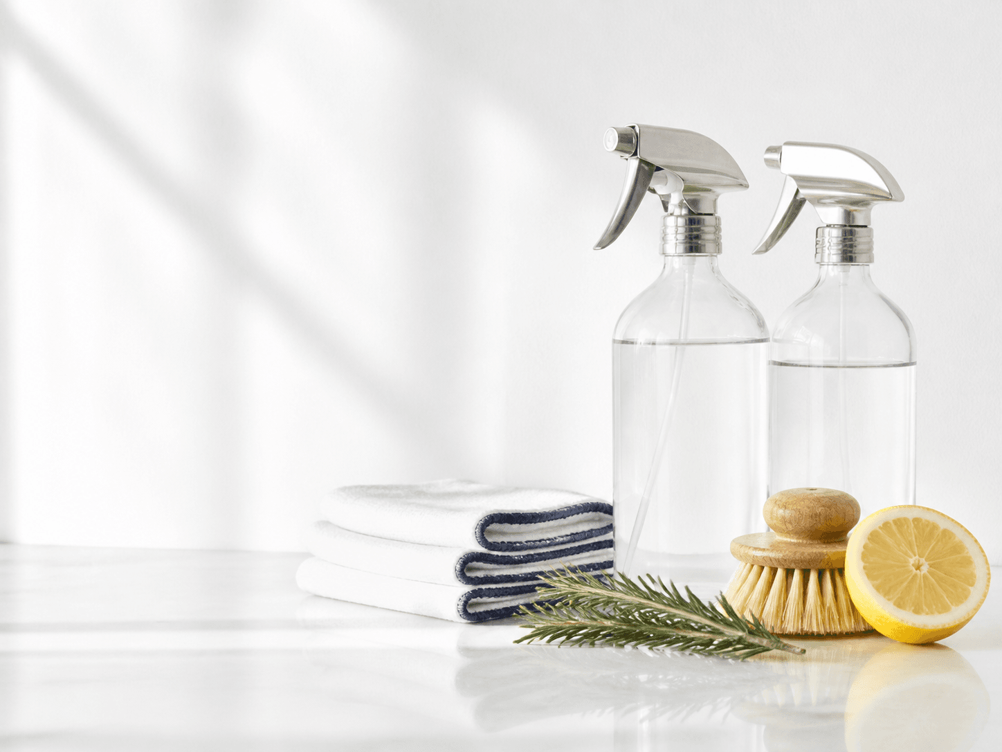 Natural cleaning supplies arranged on a white surface